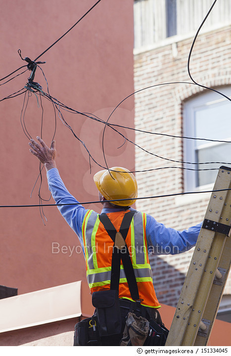 151334045 | 게티이미지코리아 | Cable lineman on ladder fixing dangling wires ...